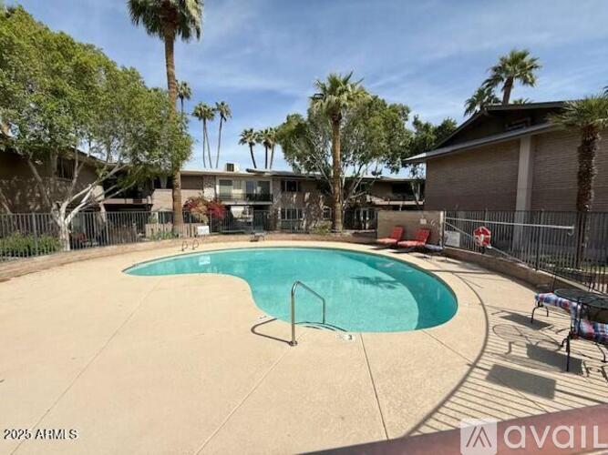 A pool surrounded by a fence and trees.