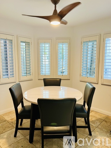 A dining room with a round table and four chairs.