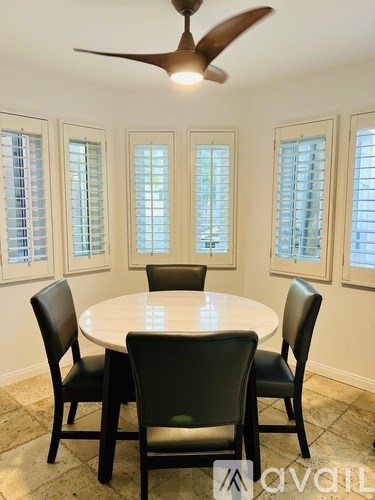 A dining room with a round table and four chairs.