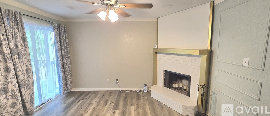 A living room with a fireplace and a ceiling fan.