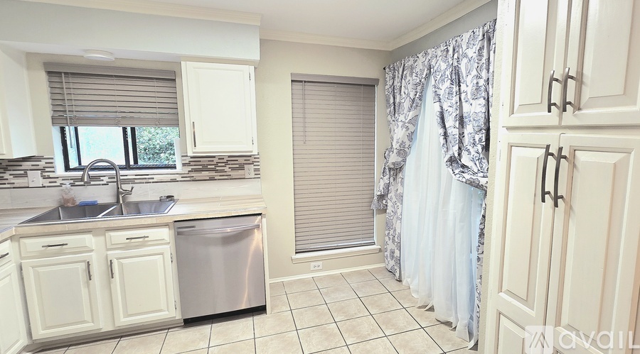 A kitchen with white cabinets and a sink.