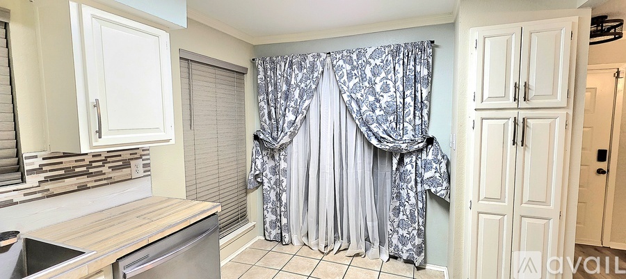 A kitchen with a shower curtain in the middle of the room.