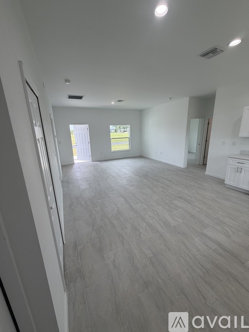 A spacious room with light grey flooring and white walls.