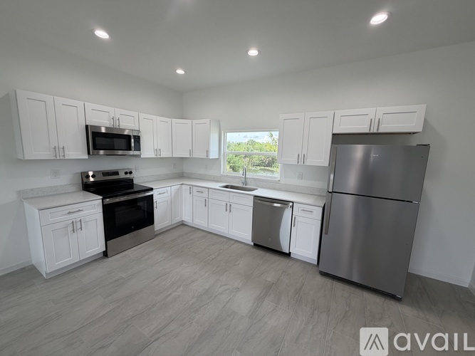 A modern kitchen with white cabinets and stainless steel appliances.