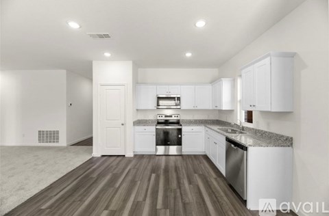 A modern kitchen with white cabinets and stainless steel appliances.