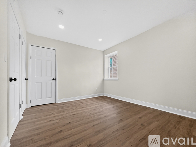 A room with wooden flooring and white walls.