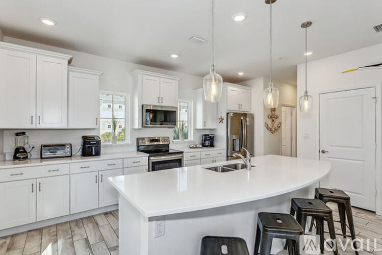 A modern kitchen with white cabinets and a large island.