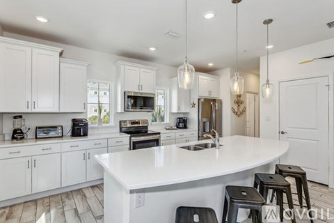 A modern kitchen with white cabinets and a large island.