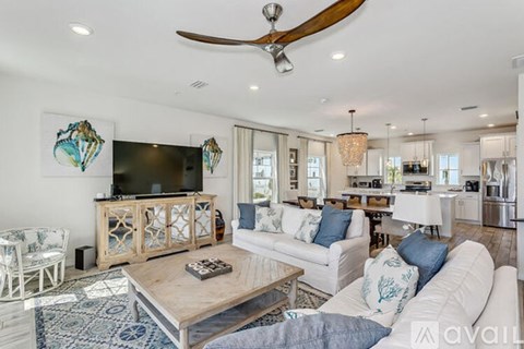 A living room with a white couch and a wooden coffee table.