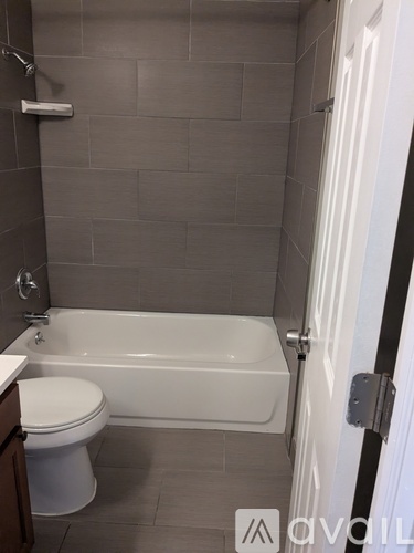 A bathroom with a white toilet and a white bathtub.