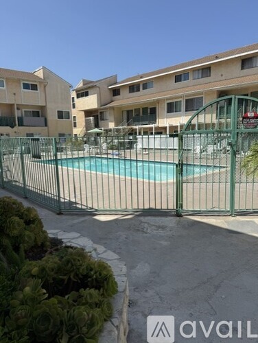 A pool surrounded by a fence and buildings.