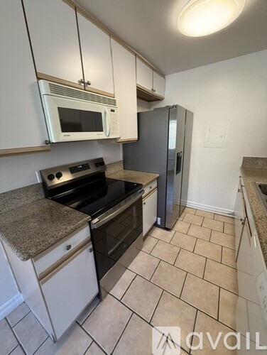 A kitchen with a granite countertop and tile flooring.