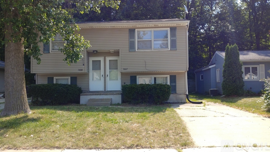 A two-story house with a white door and windows.