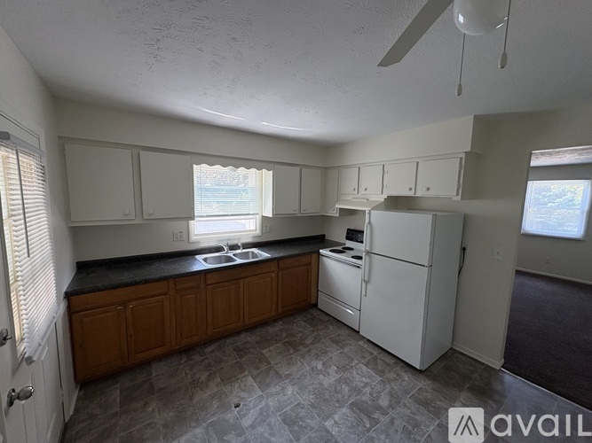 A kitchen with white appliances and wooden cabinets.