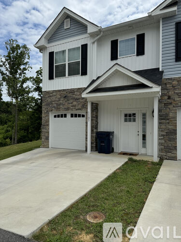A two-story house with a garage and a driveway.