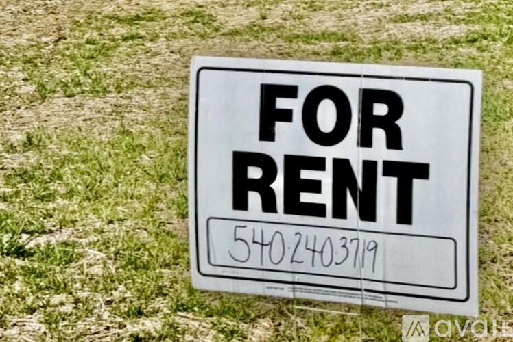 A sign that says "FOR RENT" is displayed on a grassy area.