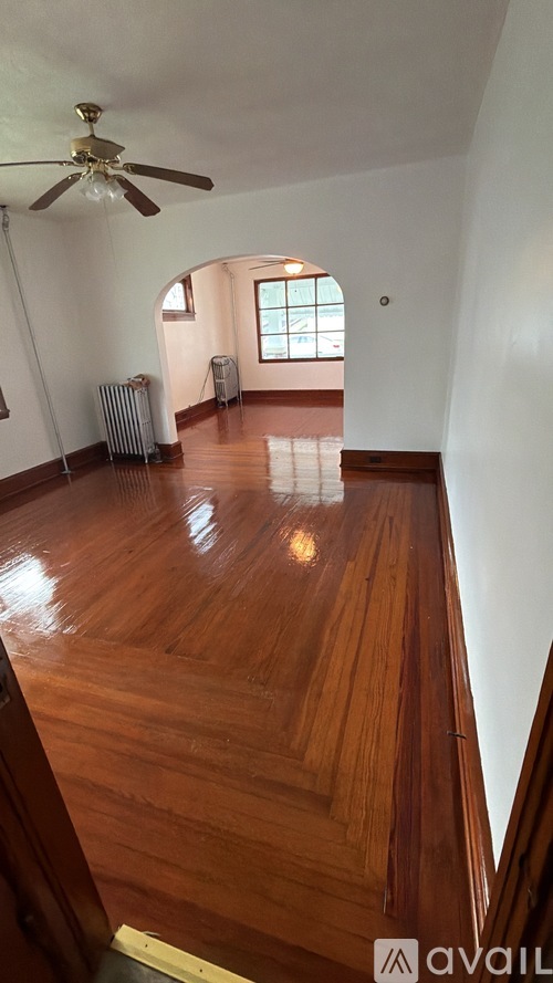 A room with wooden floors and a ceiling fan.