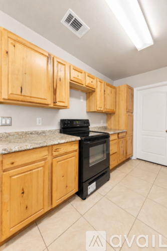 A kitchen with wooden cabinets and a black stove top oven.