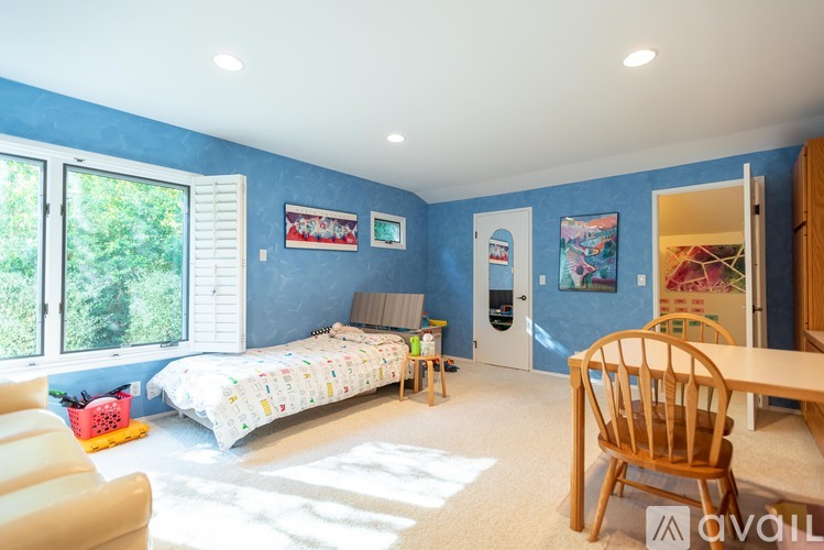 A bedroom with blue walls and a white bed.