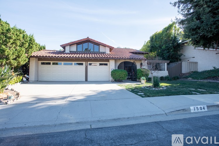 A house with a garage and a driveway in front of it.