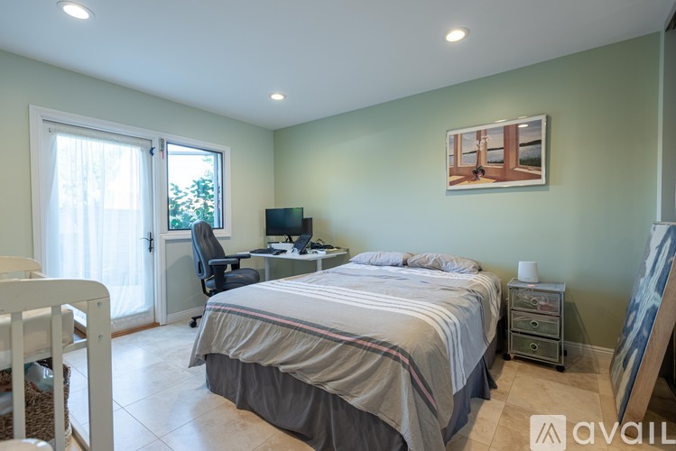 A bedroom with a bed, desk, and chair.