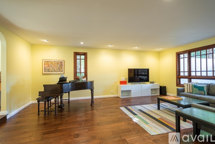A living room with a piano and a television.