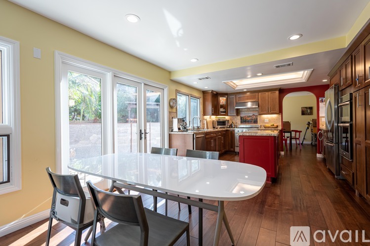 A modern kitchen with a dining table and chairs.