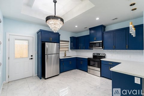 A kitchen with blue cabinets and a marble countertop.