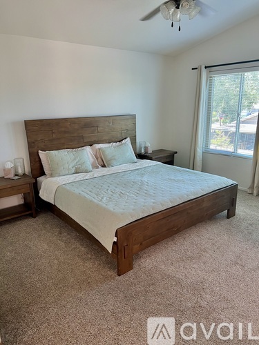 A bedroom with a large bed and a ceiling fan.