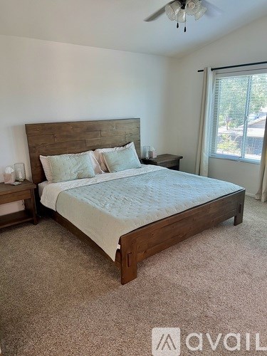 A bedroom with a large bed and a ceiling fan.