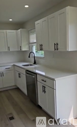 A kitchen with white cabinets and a sink.