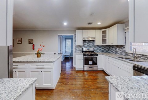 A kitchen with white cabinets and a granite countertop.