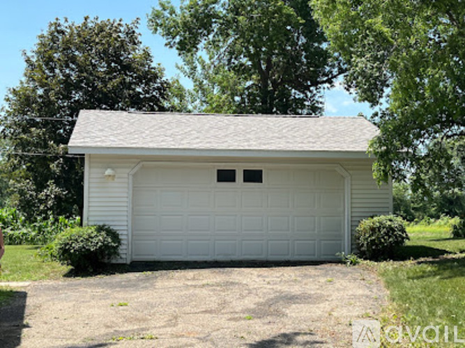 A two-car garage with a white exterior and a grey roof.