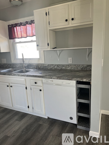 A kitchen with white cabinets and a marble countertop.