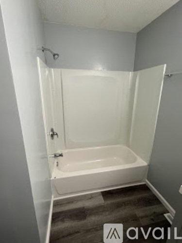 A white bathtub in a bathroom with a carpeted floor.