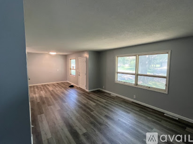 A room with wooden flooring and a window showing daylight outside.