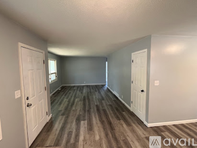 A room with wood flooring and two white doors.