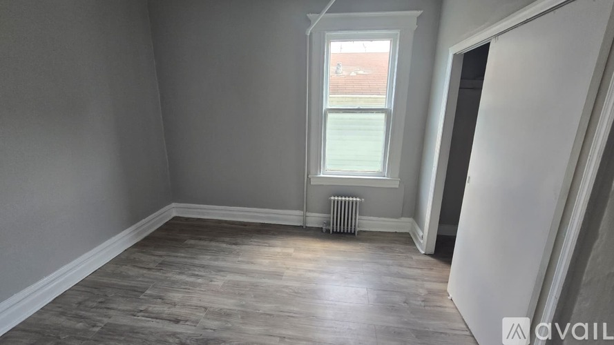 A room with a window and a radiator on the floor.
