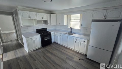 A kitchen with white cabinets and a black stove top oven.