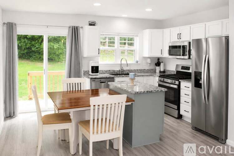 A kitchen with a table and chairs in front of a window.