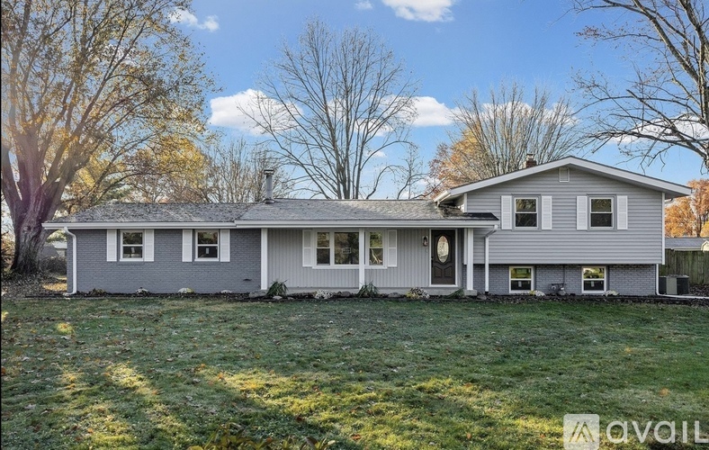 A house with a grey roof and white trim is for sale.