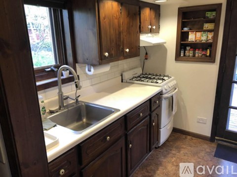 A kitchen with dark wood cabinets and a white countertop.