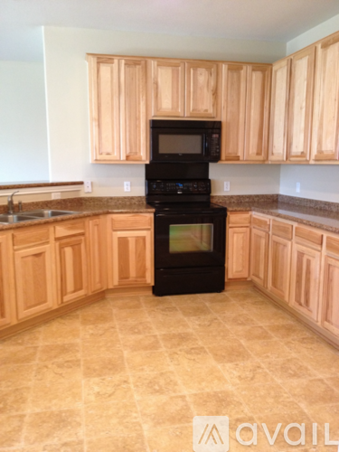 A kitchen with wooden cabinets and a black oven.