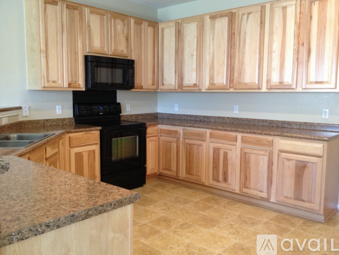 A kitchen with wooden cabinets and a black oven.