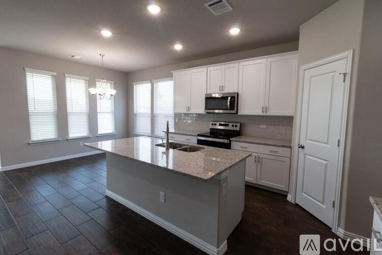 A kitchen with white cabinets and a granite countertop.