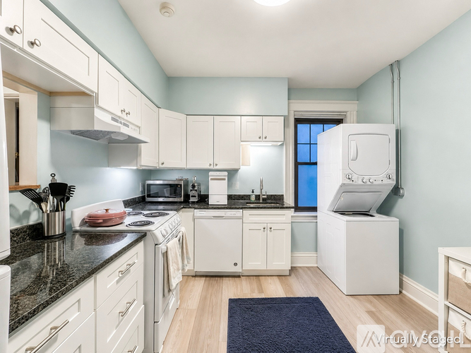 A kitchen with white cabinets and appliances.