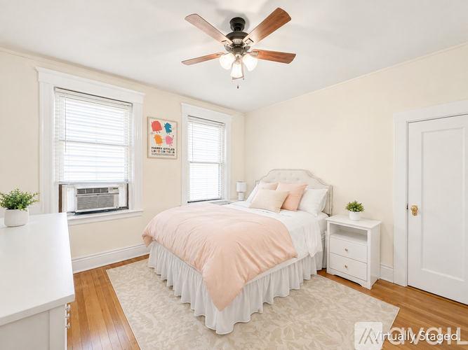A bedroom with a bed, nightstand, and window.