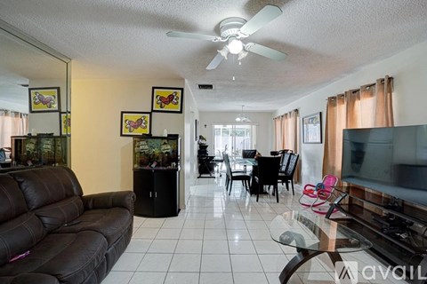 A living room with a brown leather couch and a television.