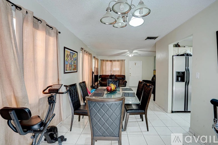 A dining room with a table set for four and a chair with a black seat and silver legs.