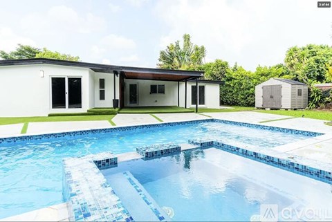 A swimming pool in front of a house.